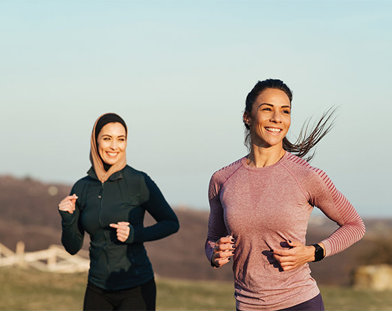 Women running in park after completing medical weight loss program and making healthy lifestyle changes.